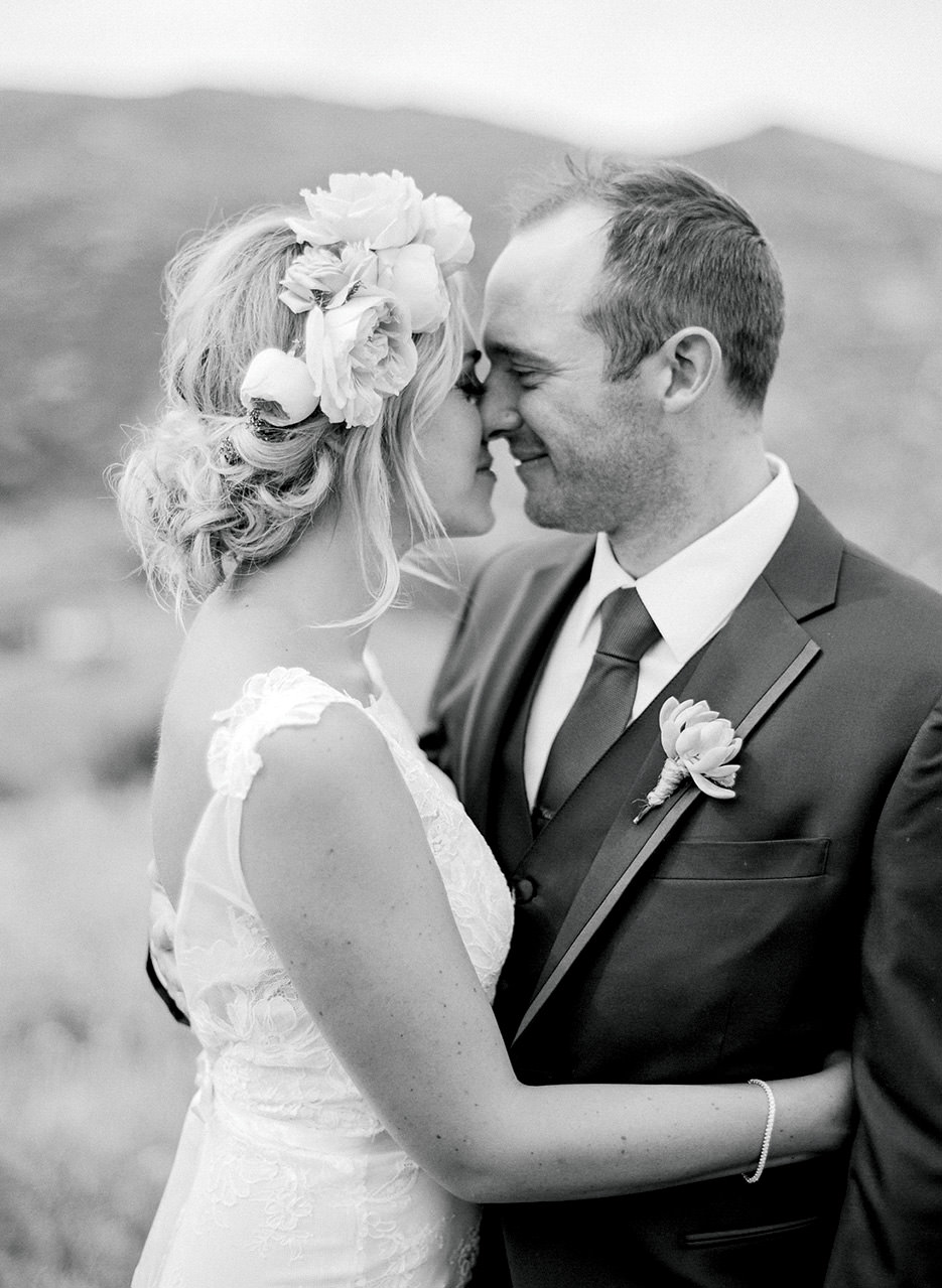 A close embrace and nuzzle of a bride and groom in black and white
