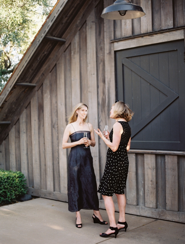 Guests chat with wine in front of an industrial barn at Ram's Gate. 