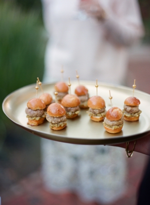 A gold tray of mini hamburgers is passed as hors d'oeuvres at a city wedding in San Francisco.