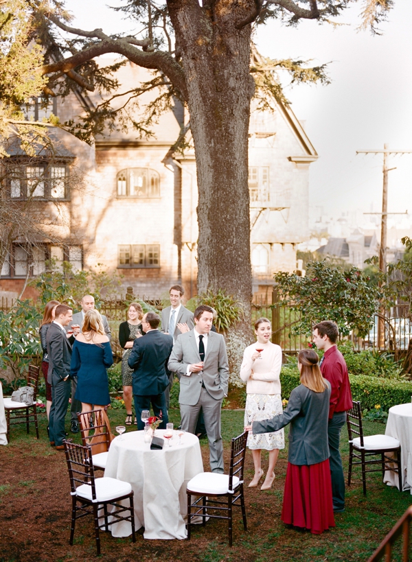 Cocktail hour with guests in the garden of an intimate city wedding at the Swedenborgian Church in San Francisco.