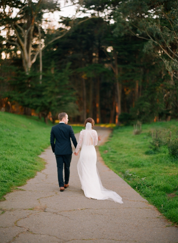 A bride and groom walk away together in the sunset to Lovers Lane in the Presidio in San Francisco. 