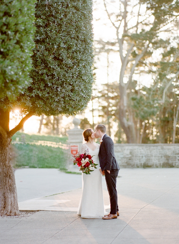 A bride and groom kiss in the Presidio in San Francisco near Lovers Lane. 