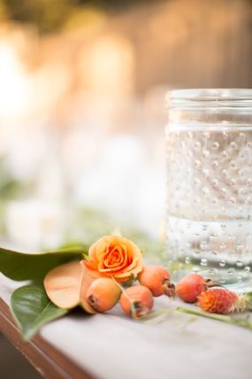 Peach rose adon a table sitting next to a ball jar filled with water at Holman Ranch. 
