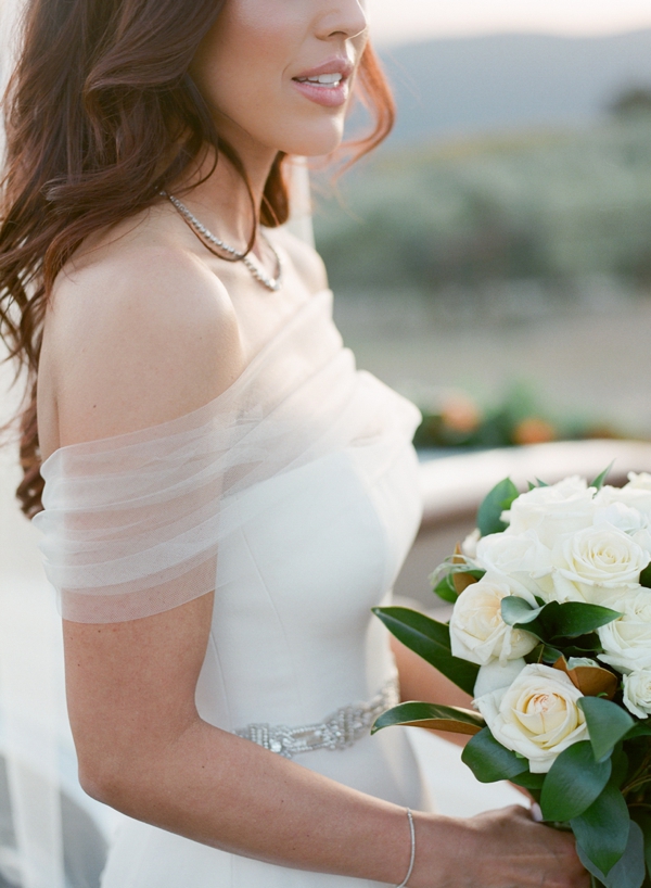 Beautiful bride stands with a white rose bouquet at Holman Ranch in Carmel Valley.