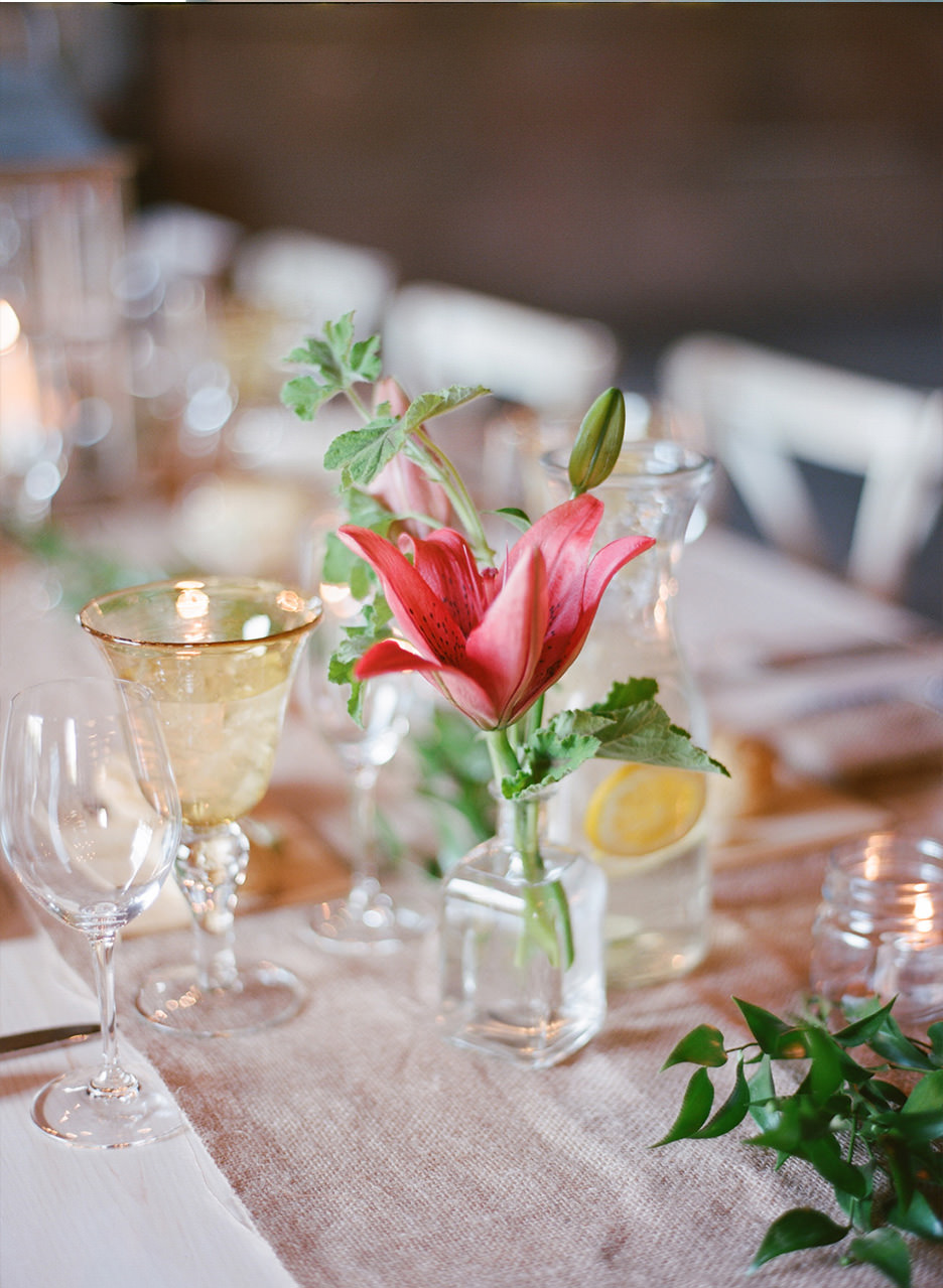 A pink flower is the center of a gold and pink tablescape.