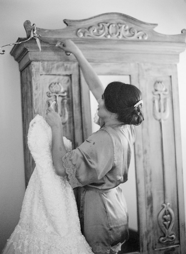 bride taking her dress off the hanger to get dressed