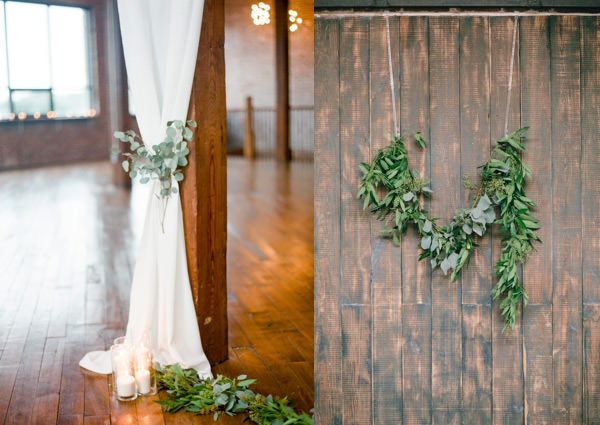 Olive branches serve as a beautiful accent to a wood plank wall for guests to take photos in front of.