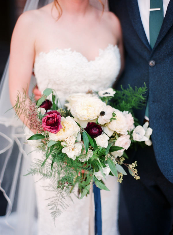 Close up of the bride holding her bouquet of white anemones and magenta ranunculus by Old Forest Farm Indianapolis Biltwell Wedding Photographers